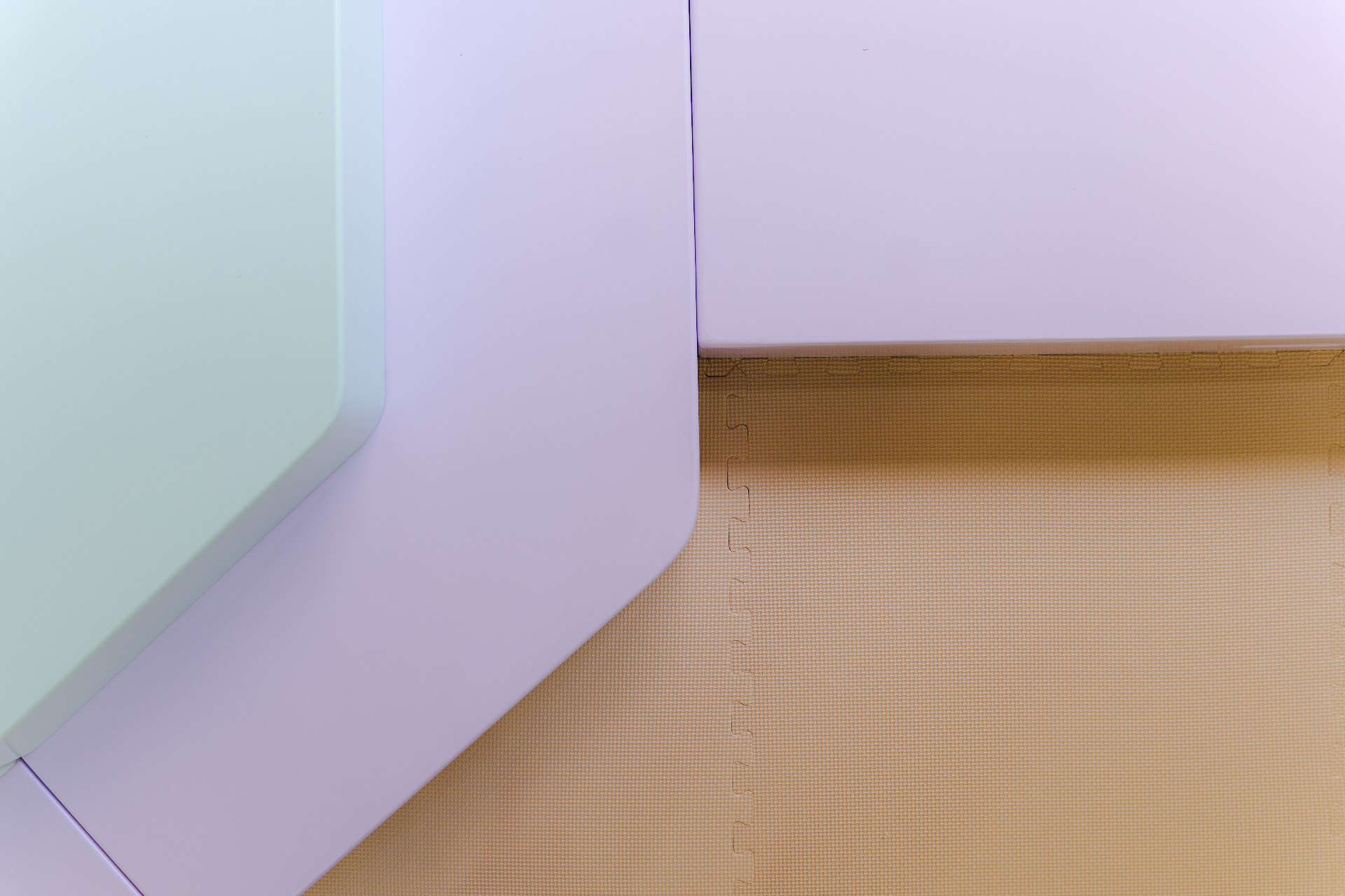 Espacio infantil diseñado por Amanda Simó Studio — plataforma en tonos lavanda y azul con suelo texturizado